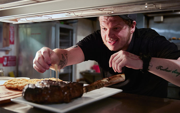 chef sticks toothpick in steak 